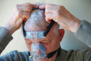 man putting on a sleep apnea mask