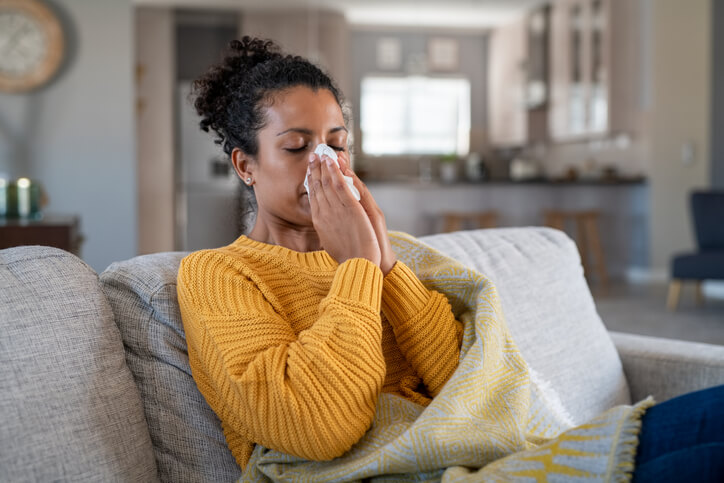 A woman sneezing with the flu