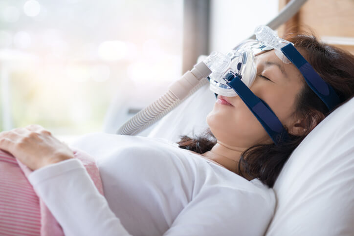an image of a woman wearing a sleep apnea mask